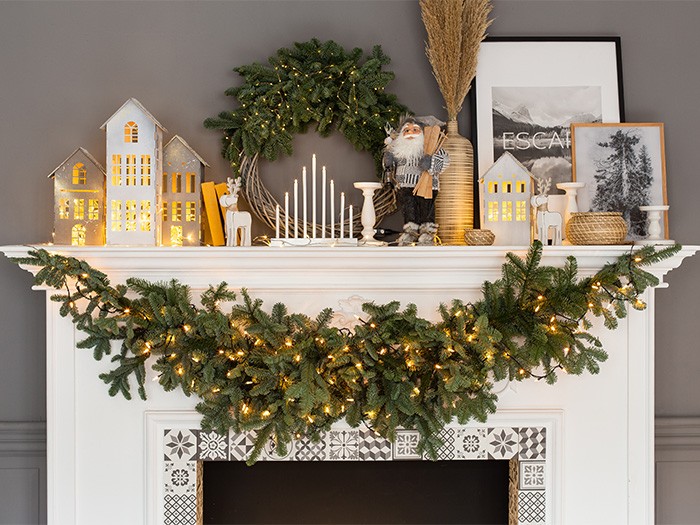White fire place with gray walls and greenery accent on mantel